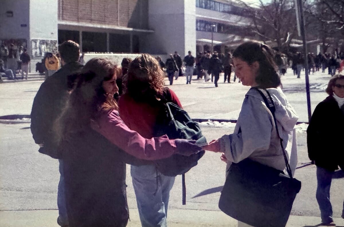 IMG_1232 copy woman handing out coupon books on a college campus